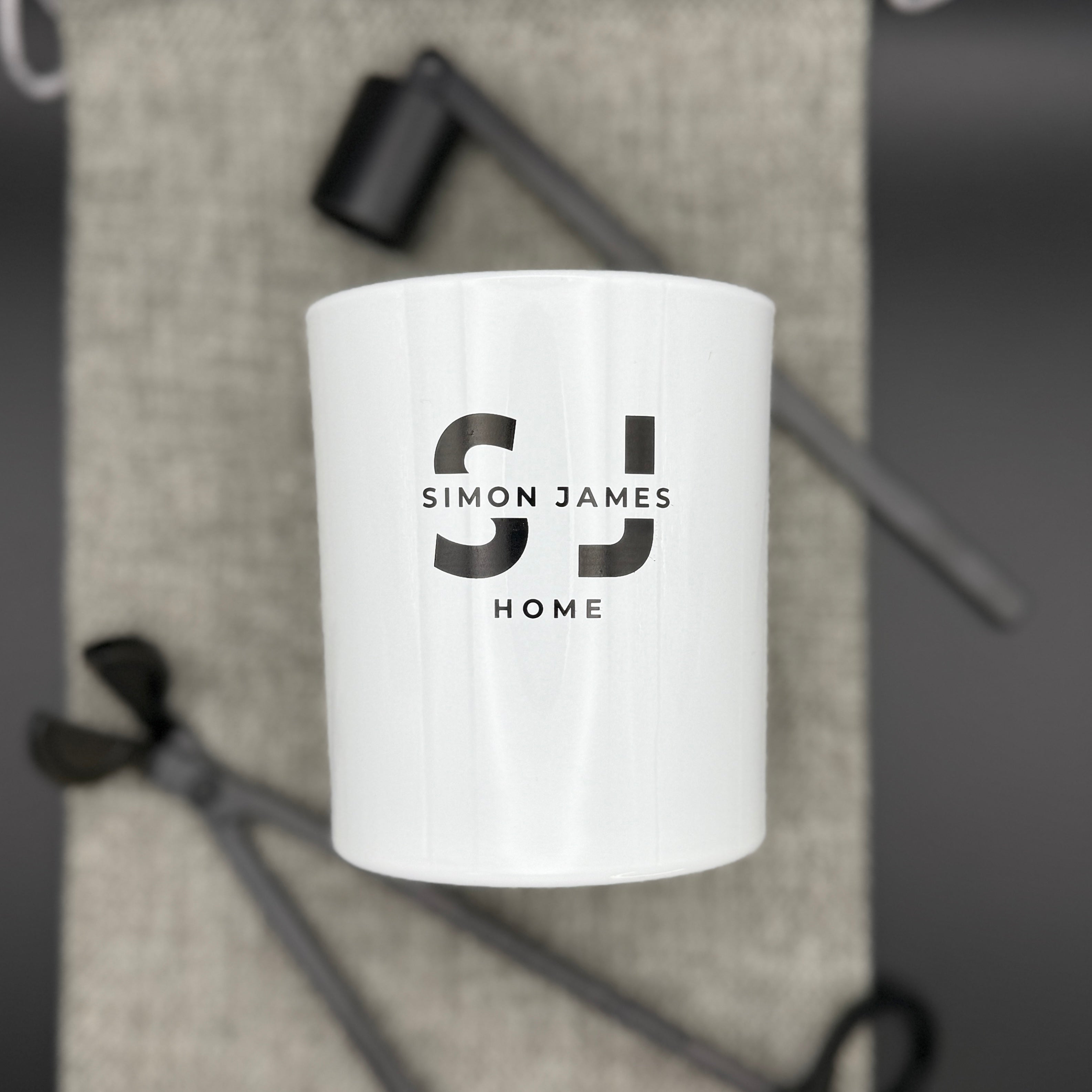 White glass candle jar from Simon James Home with candle accessories, showcasing sustainable home decor and candle jar reuse ideas.